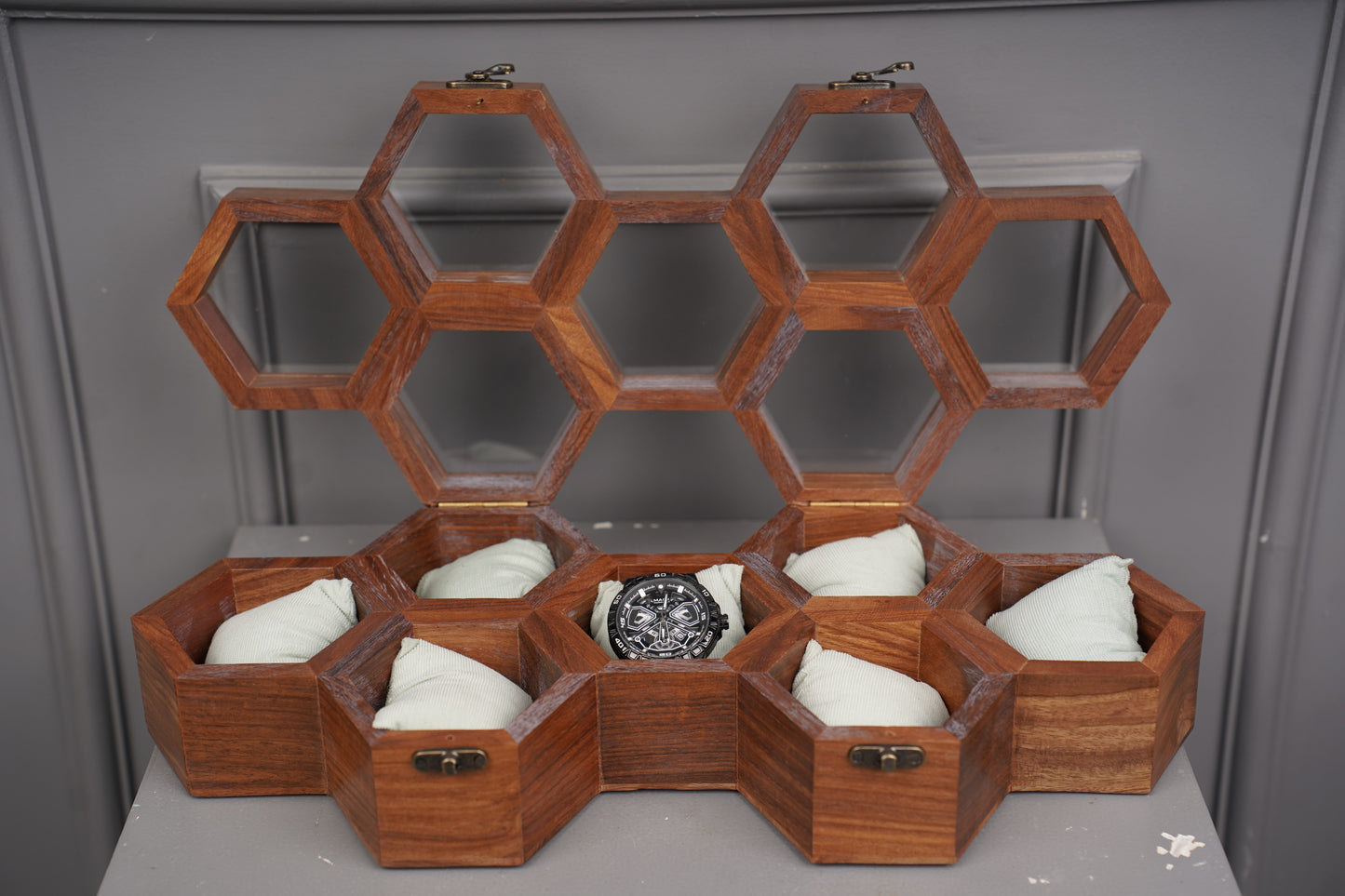 Wooden honeycomb structure with hexagonal compartments on a gray background