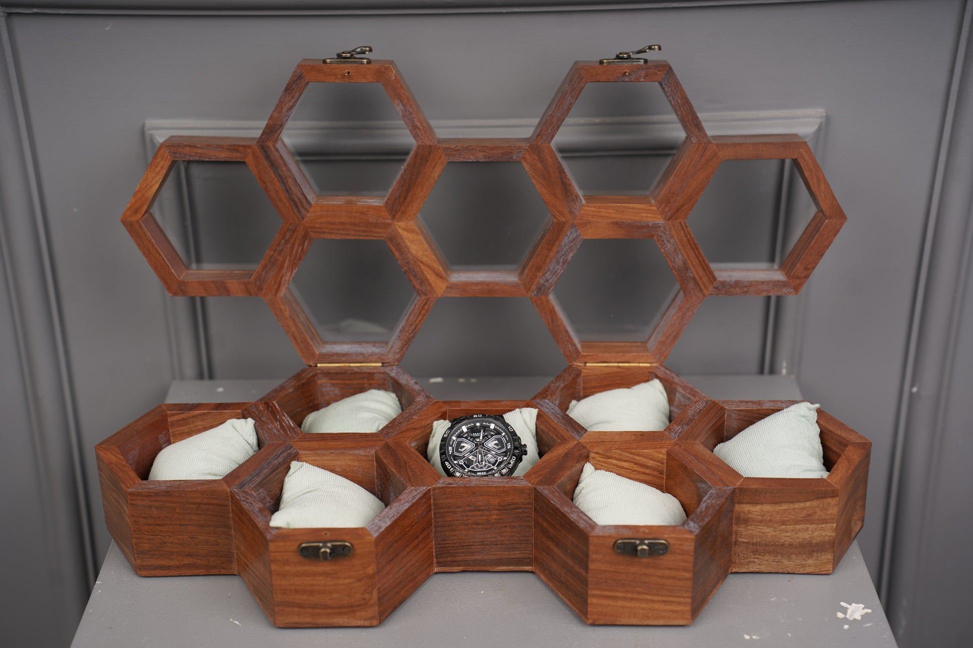 Wooden honeycomb structure with hexagonal compartments on a gray background