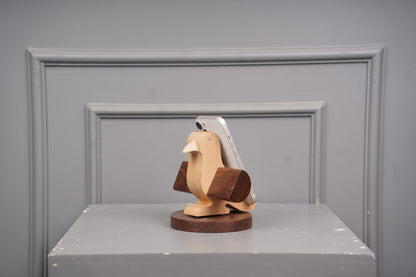 Wooden bird sculpture on a gray surface with a gray background