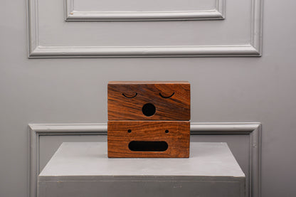 Wooden box with facial expressions on a gray surface