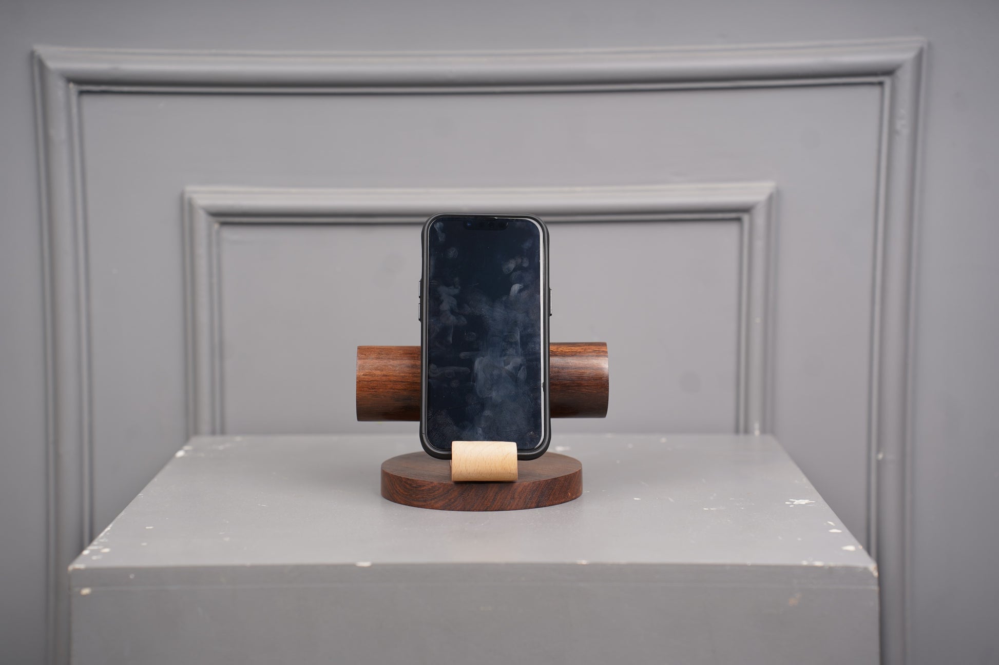 Smartphone on a wooden stand against a gray background