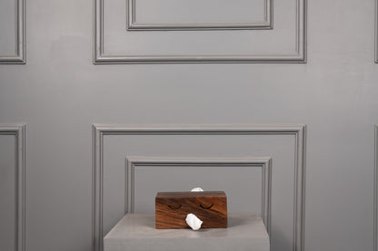 Wooden box with a white object on a gray surface against a gray paneled wall