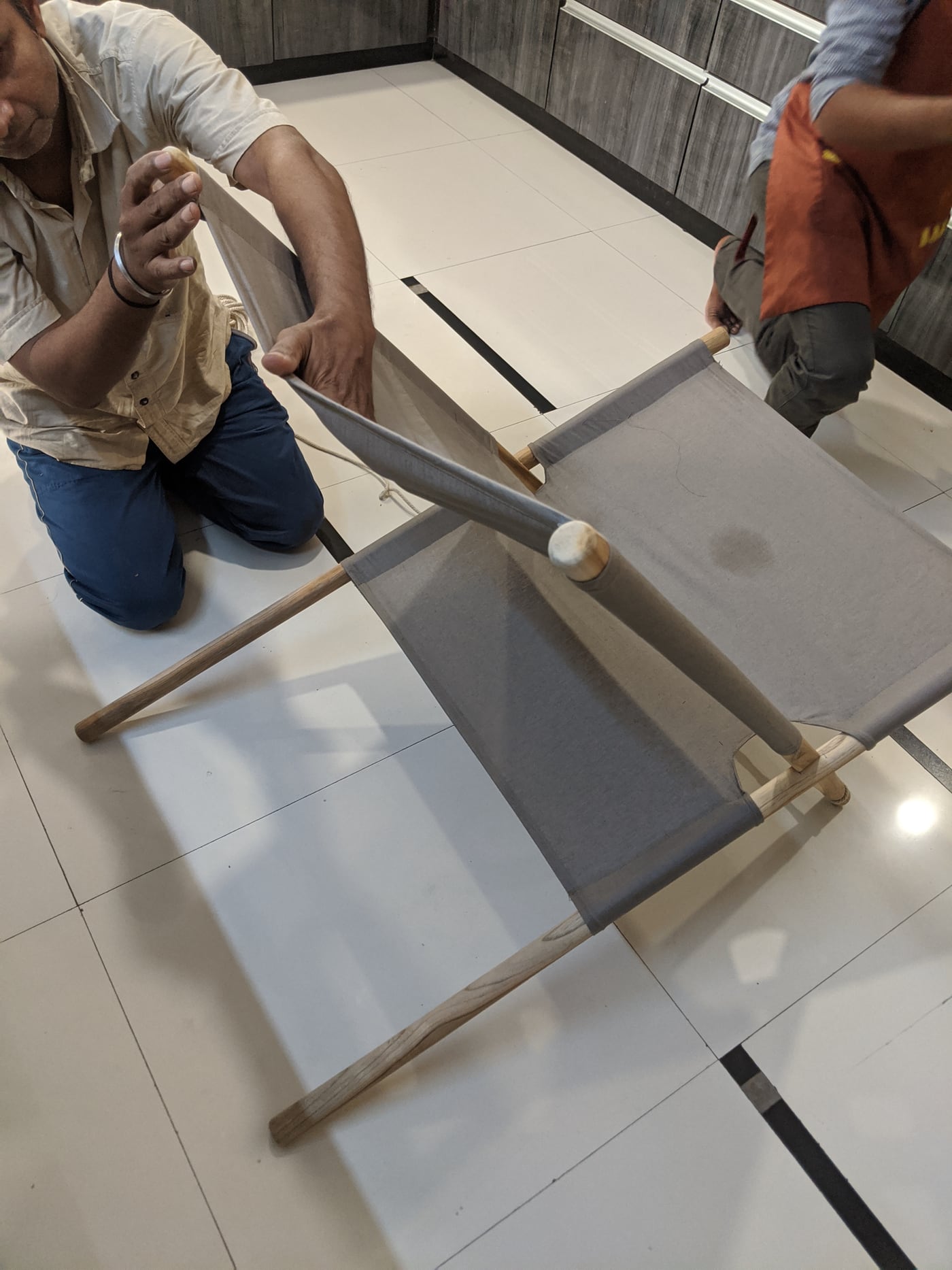 A handcrafted wooden and fabric chair being assembled